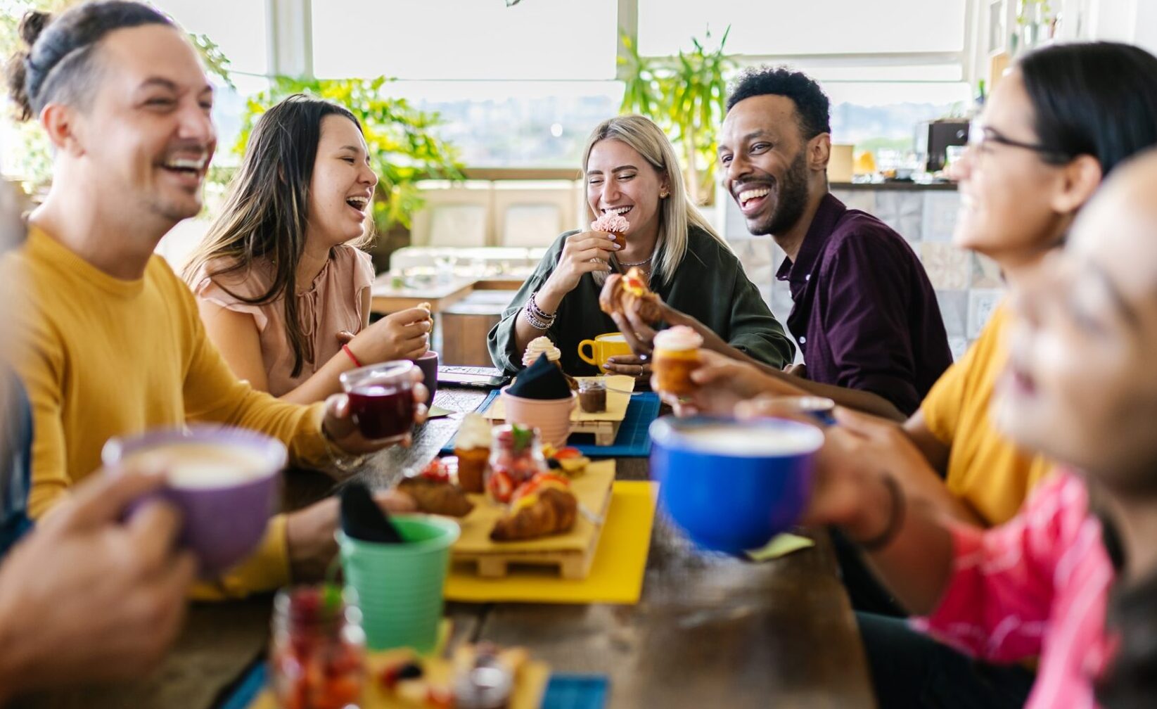 Multiracial people gathering together while having breakfast on rooftop cafe restaurant